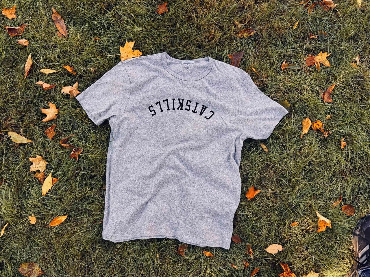 Catskills tee by The Graham & Co laid on autumn grass